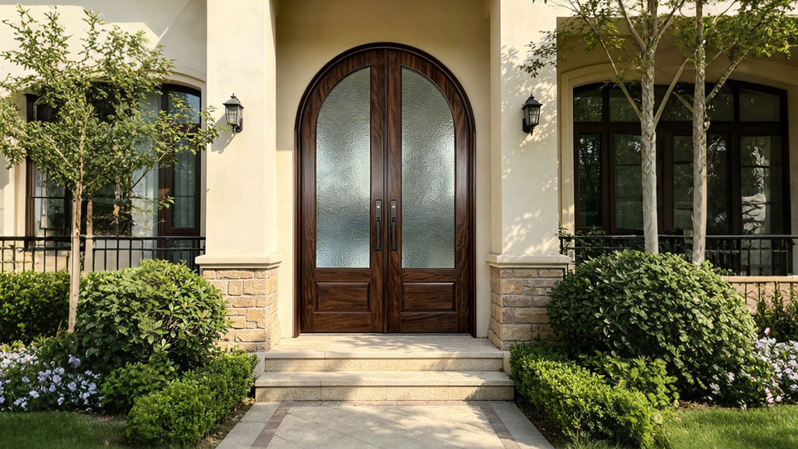Elegant French style arched solid wood and glass front double door installed in a luxury building exterior